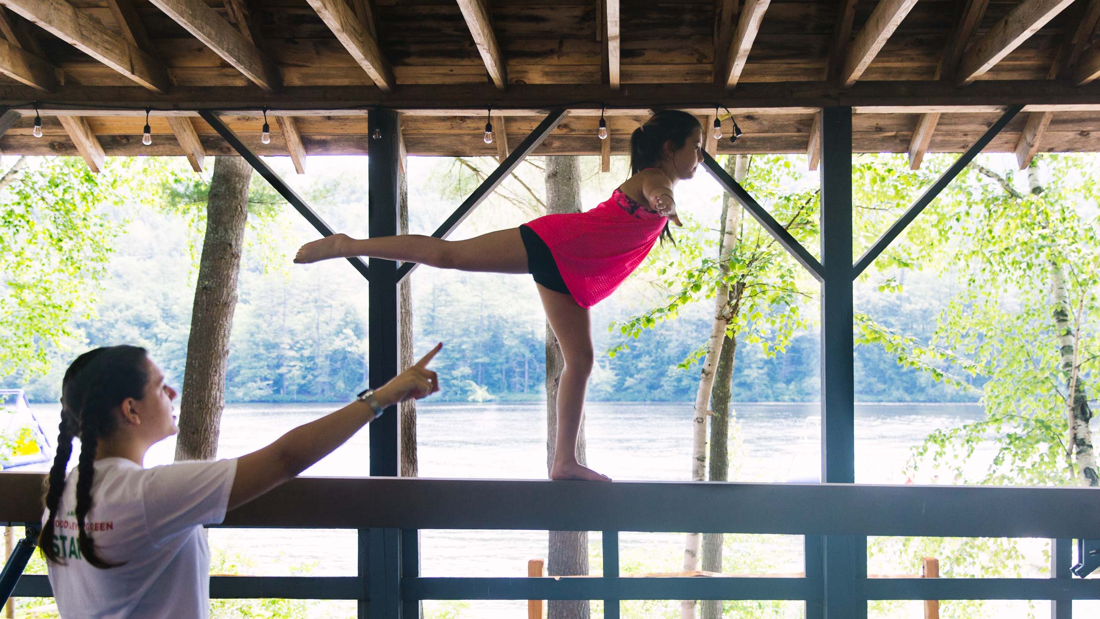 Girl standing on one foot on gymnastics balance beam