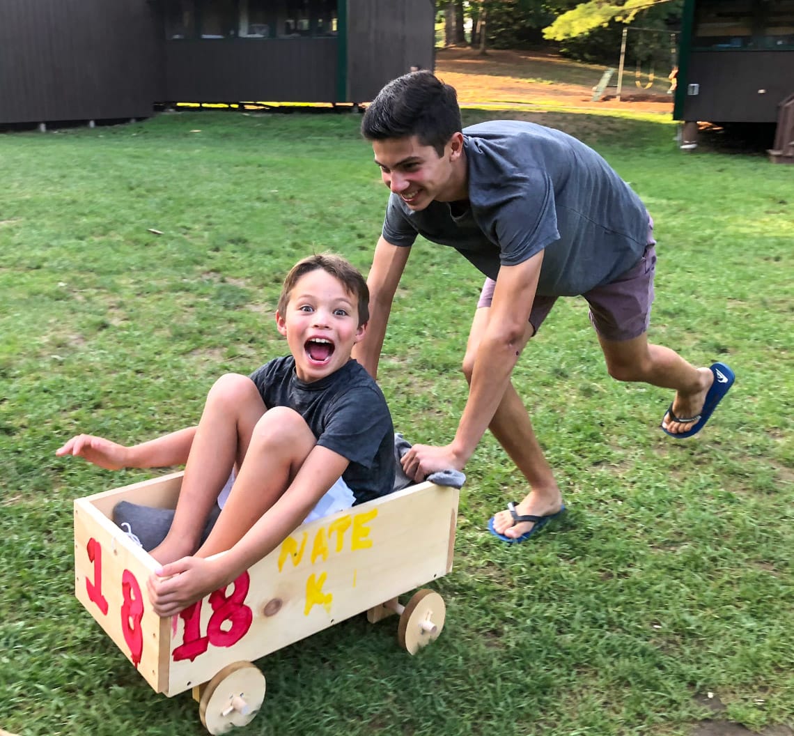 Big Brother pushing Little Brother in wagon